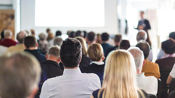 Audience hört Speaker bei einem Business Meeting zu