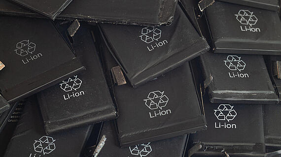 Nahaufnahme alter, gebrauchter Lithium-Polymer-Akkus von Mobiltelefonen, die für das Recycling vorbereitet werden.
